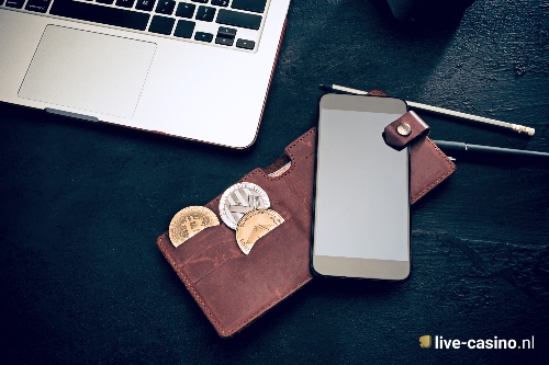 A mobile and wallet showing 3 different crypto coins